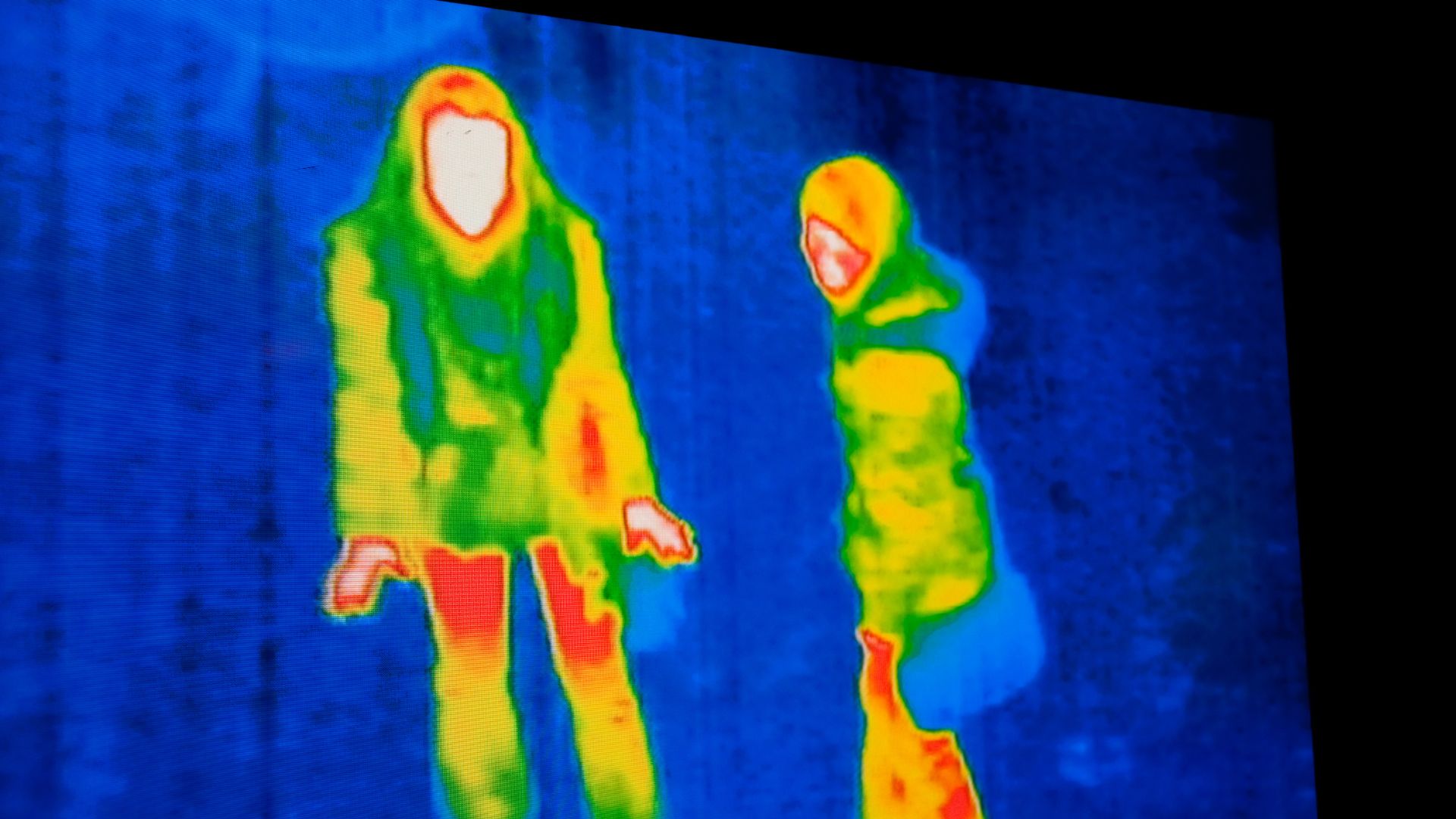 Thermal infrared image showing heat signatures of two human figures